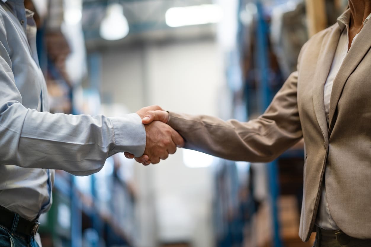 Warehouse manager shaking hands with supervisor