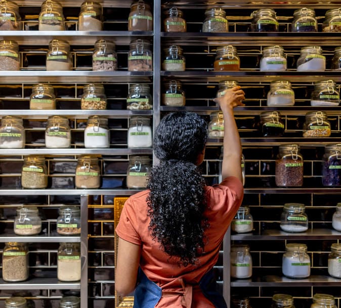 Rear view of a waitress organizing the spices at a restaurant